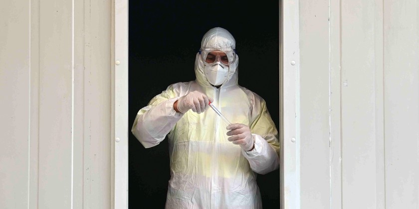 Một chuyên gia chăm sóc sức khỏe làm việc tại một trạm thử nghiệm Covid-19 ở Đức. Ảnh: AFP.