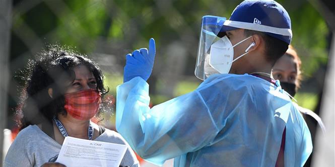 Nhân viên y tế hướng dẫn người dân tại điểm xét nghiệm Covid-19 ở San Fernando, California, Mỹ, ngày 24/11/2020. Ảnh: AFP/TTXVN