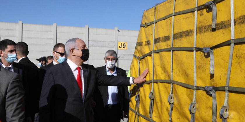 Thủ tướng Israel Benjamin Netanyahu chạm vào lô vắc-xin Pfizer đầu tiên hạ cánh tại sân bay Ben Gurion vào ngày 9/12/2020. 
