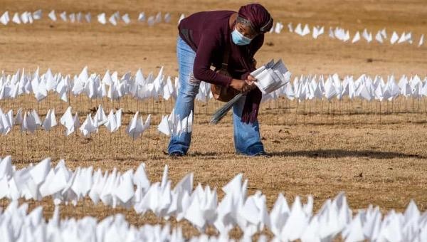 Người phụ nữ cắm hơn 10.000 lá cờ trắng tượng trưng cho những ca tử vong liên quan đến đại dịch Covid-19 ở Georgia vào đầu tháng 1. Ảnh: EPA.
