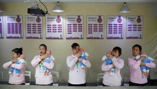 Sinh viên tại Đại học Ayi thực hành trên búp bê trẻ em trong một khóa học dạy chăm sóc trẻ em ở Bắc Kinh, Trung Quốc ngày 5/12/2018. Ảnh: REUTERS.