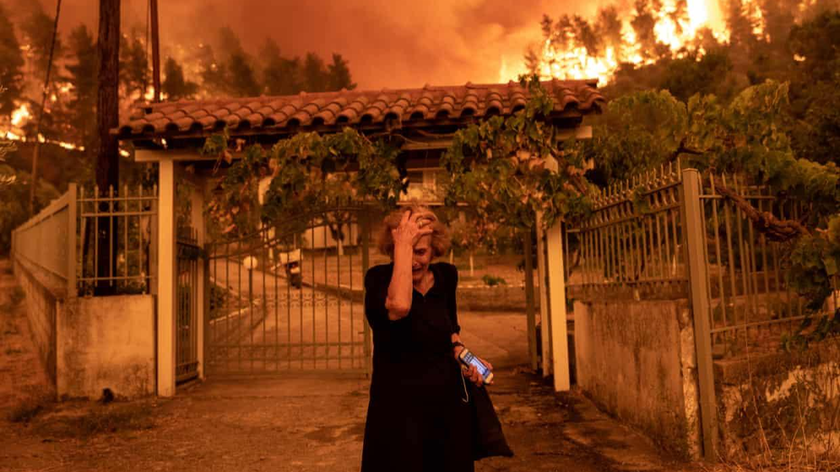 Một người phụ nữ phản ứng khi đám cháy rừng đến gần ngôi nhà của mình ở Evia, Hy Lạp.