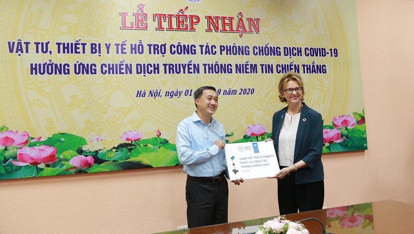 Thứ trưởng Bộ Y tế Trần Văn Thuấn nhận ủng hộ của UNDP từ bà đại diện thường trú của UNDP tại Việt Nam bà Caitlin Wiesen. Ảnh: Bộ Y tế