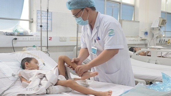 Bác sĩ khoa hồi sức tích cực chống độc trẻ em Bệnh viện Bệnh nhiệt đới kiểm tra sức khoẻ cho bệnh nhi A.P. Ảnh: Công an nhân dân