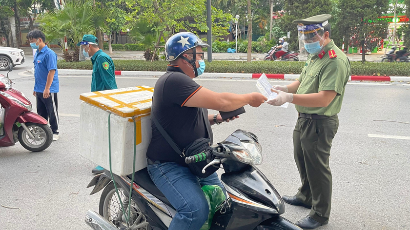 Lực lượng chức năng kiểm tra giấy đi đường của người dân khi Hà Nội giãn cách toàn thành phố. Ảnh: Mỵ Châu