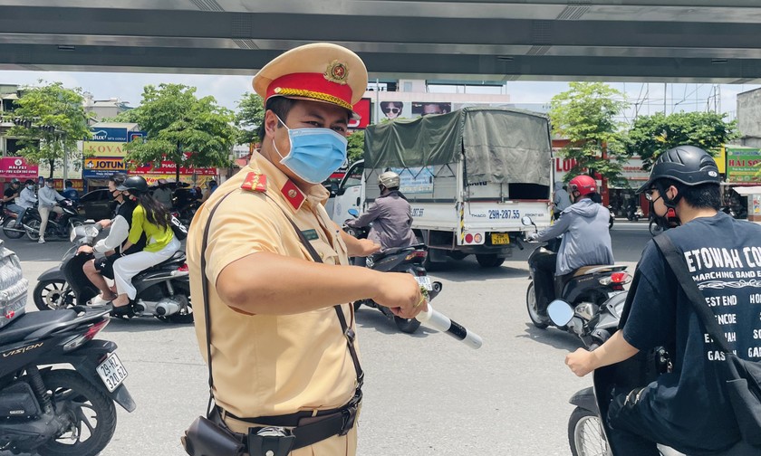 Đại úy Trần Phương Tiến làm nhiệm vụ phân luồng giao thông giữa trời nắng nóng.