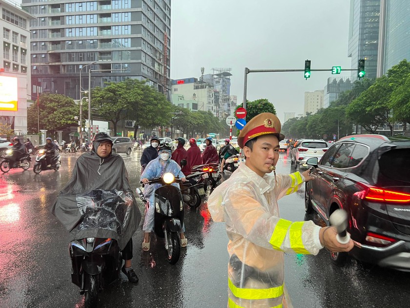 Hình ảnh chiến sĩ CSGT( Công an Tp.Hà Nội) phân luồng giao thông trong trận mưa lớn sáng nay.