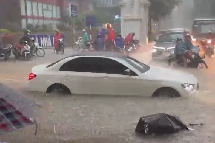 Nước mưa ngập ngang bánh xe ô tô.