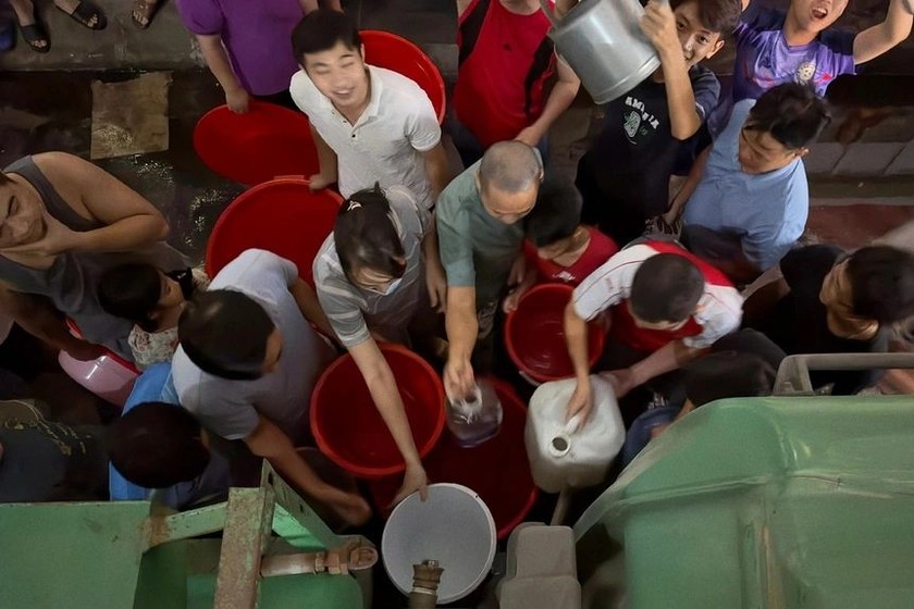 Người dân ở khu đô thị Thanh Hà phải bê xô, chậu đi xếp hàng hứng nước xuyên đêm về sử dụng. Ảnh: Người dân cung cấp.