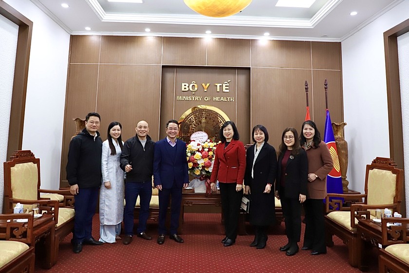 TS Vũ Hoài Nam - Tổng biên tập Báo Pháp luật Việt Nam (thứ 4 từ trái sang) tặng hoa chúc mừng Bộ trưởng Bộ Y tế Đào Hồng Lan (thứ 4 từ phải sang).