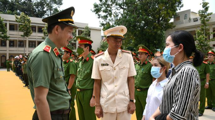 Giám đốc Công an tỉnh Đồng Nai Vũ Hồng Văn và Đại úy Thái Ngô Hiếu trò chuyện với người thân các nạn nhân được cứu sống.