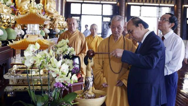 Chủ tịch nước Nguyễn Xuân Phúc thực hiện nghi thức tắm Phật tại chùa Huê Nghiêm.