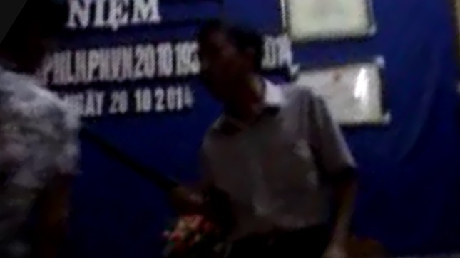 An ninh thôn Văn Nhuế dùng dùi cui đánh người tại nhà văn hóa thôn. (ảnh cắt từ clip).