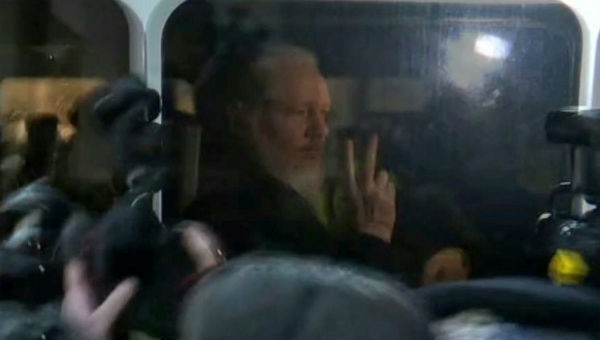 Ông Julian Assange trên xe cảnh sát.