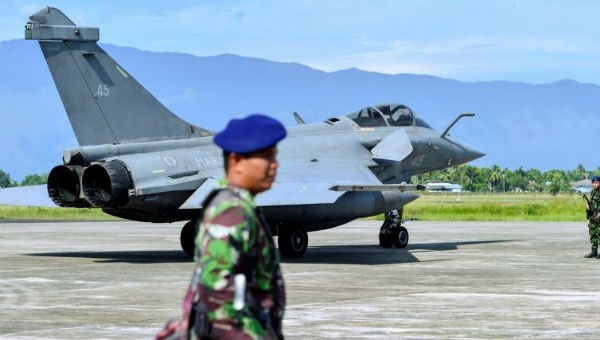 Binh lính Indonesia canh gác gần 1 máy bay chiến đấu của Pháp