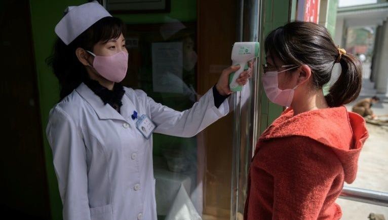 Nhân viên y tế kiểm tra thân nhiệt của người dân ở Triều Tiên.