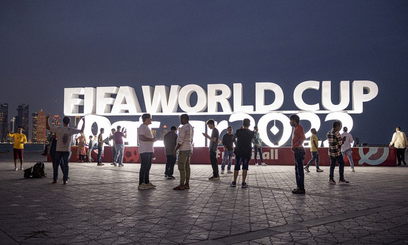 Người hâm mộ thể thao chụp ảnh trước biển hiệu FIFA World Cup Qatar 2022.