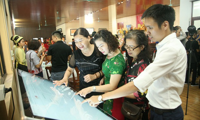 Du khách trải nghiệm ứng dụng du lịch thông minh tại Trung tâm Thông tin du lịch làng nghề Bát Tràng (Hà Nội). Ảnh: VGP