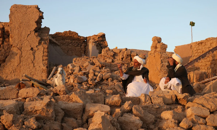 Người dân Afghanistan ngồi trên một ngôi nhà đã bị sập hoàn toàn do động đất ở tỉnh Herat.