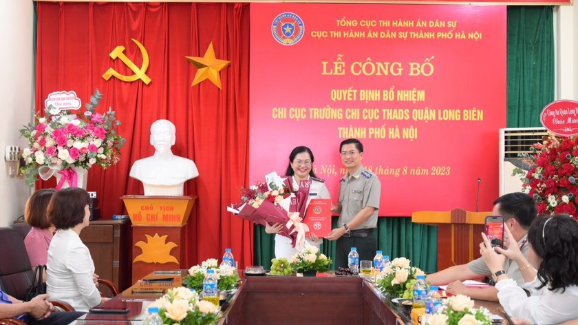 Cục trưởng Cục THADS thành phố Hà Nội Phạm Văn Dũng trao Quyết định và tặng hoa chúc mừng cho đồng chí Nguyễn Thị Bích Vân.