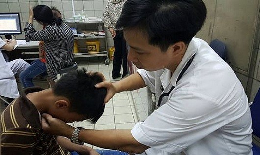  Bác sĩ khám gáy cho bệnh nhi để kiểm tra hội chứng màng não (Hình: H.Hải/dantri.com.vn)