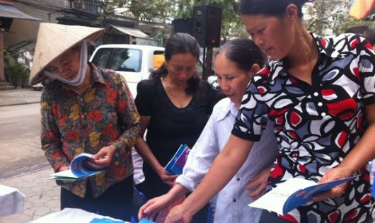 Nữ lao động di cư đang xem các tài liệu tư vấn về sức khỏe, pháp luật.