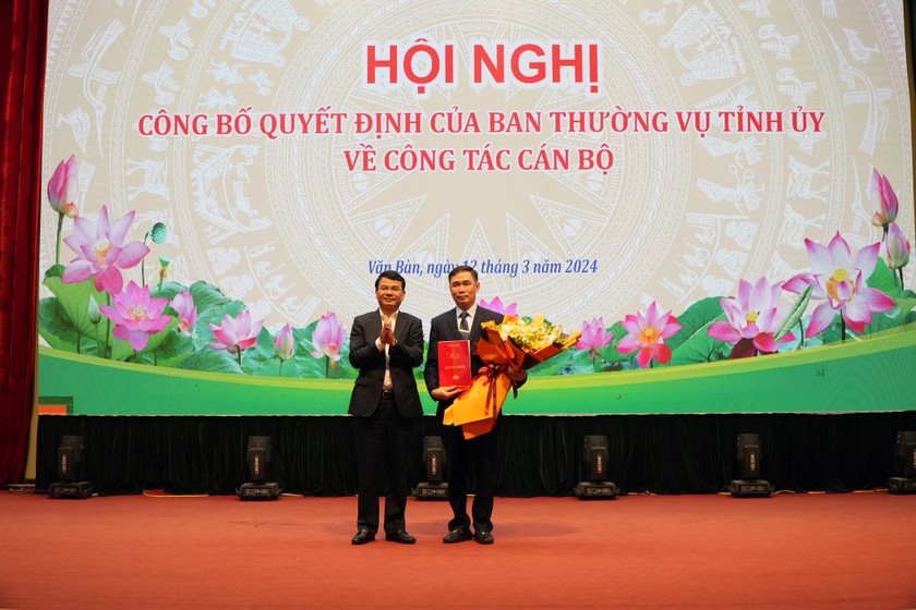 Bí thư Tỉnh ủy Lào Cai Đặng Xuân Phong trao quyết định và tặng hoa cho tân Bí thư huyện ủy Văn Bàn Nguyễn Anh Chuyên.