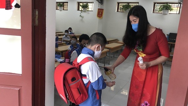 Học sinh Trường tiểu học Nguyễn Công Trứ (Quận Lê Chân) được các thầy cô giáo hướng dẫn sát khuẩn tay trước khi vào lớp học
