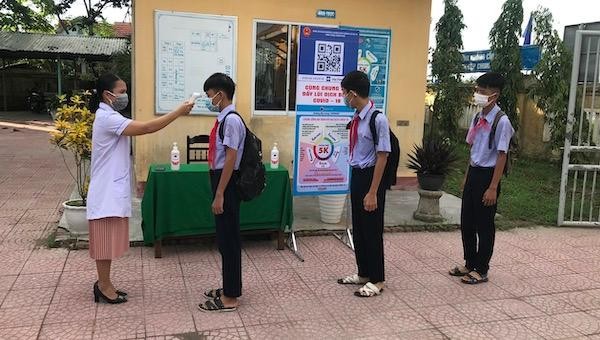 Học sinh trường THCS Hà Thế Hạnh (thị xã Hương Trà) được kiểm tra nhiệt độ khi vào học