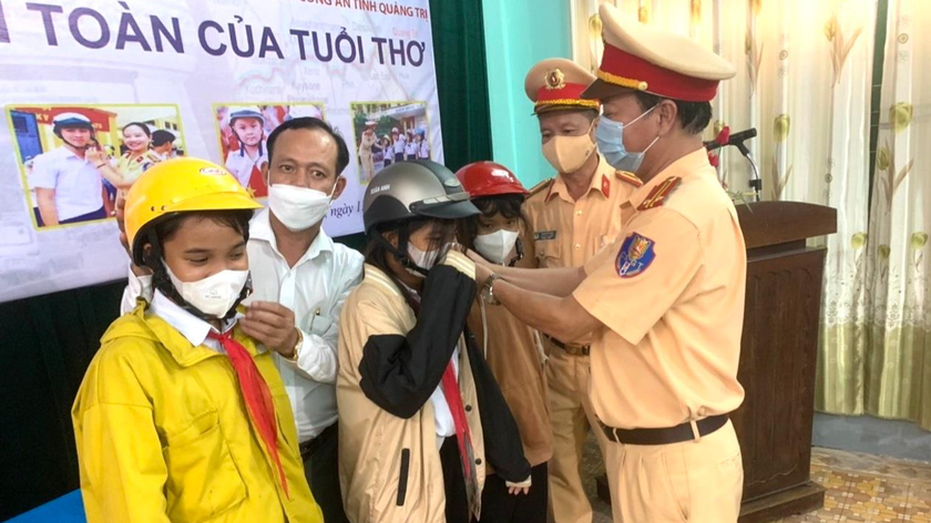 Các em rất phấn khởi khi nhận mũ từ Phòng CSGT tỉnh Quảng Trị và VPĐD Báo PLVN khu vực Bình Trị Thiên trao tặng.