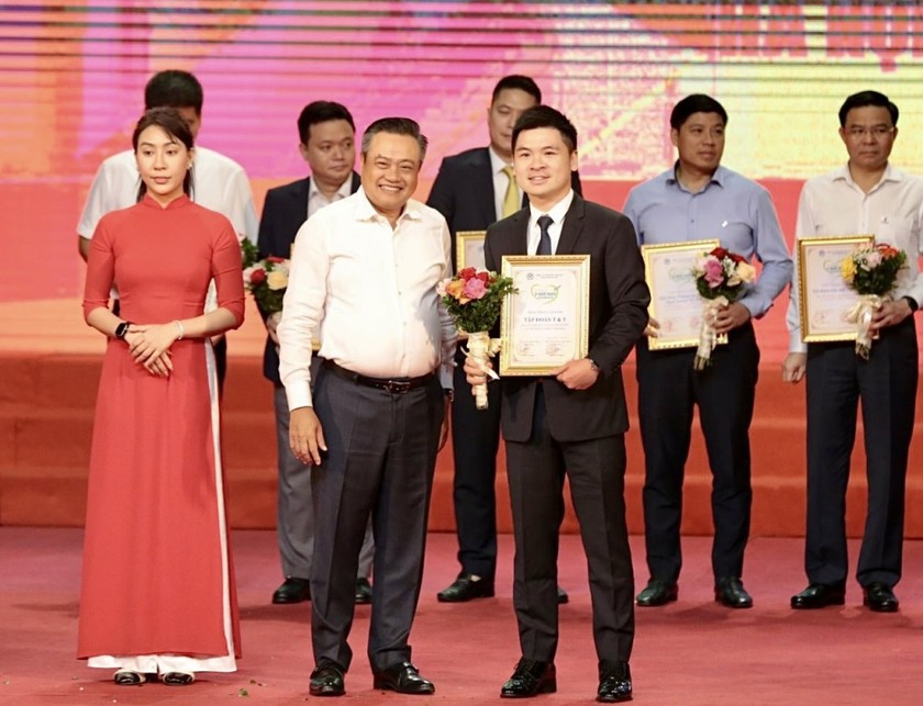 Ông Trần Sỹ Thanh, Chủ tịch UBND TP Hà Nội (trái) tặng hoa ông Đỗ Vinh Quang, Phó Chủ tịch Tập đoàn T&T Group nhằm tuyên dương, vinh danh đơn vị này vì những đóng góp cho công tác an sinh xã hội của Thành phố.