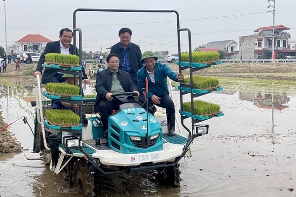 Thủ tướng trực tiếp ngồi máy cấy để điều khiển cấy lúa trên cánh đồng - Ảnh: VGP/Nhật Bắc 