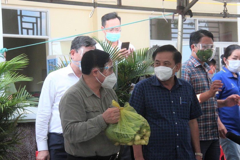 Thủ tướng Phạm Minh Chính kiểm tra phần thực phẩm chuẩn bị trao cho người dân.