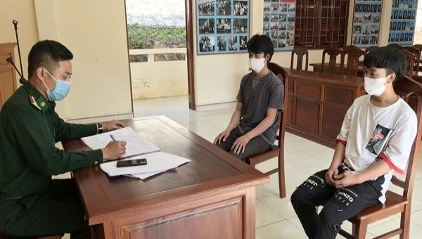 Lực lượng chức năng đang làm việc với hai thanh niên vượt biên trái phép từ Lào về Việt Nam.