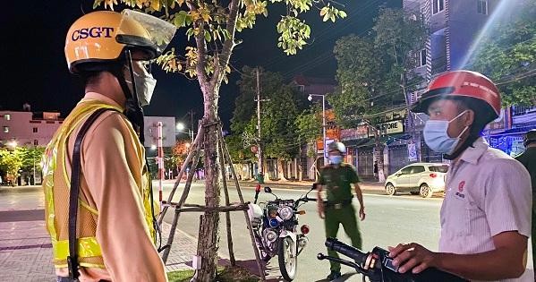 Lực lượng CSGT, Công an thành phố Quảng Ngãi nhắc nhở người dân không được ra đường sau 21h.