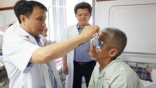 GS. TS Phạm Như Hiệp, Giám đốc Bệnh viện Trung ương Huế tháo băng cho bệnh nhân Phan Hữu Lạc sau ca ghép giác mạc