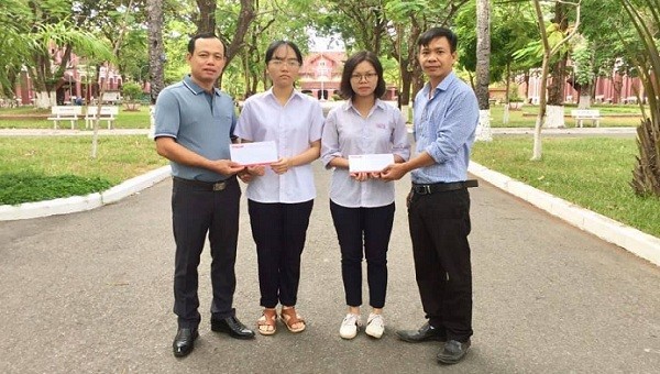 Nhà báo Nguyễn Quang Tám-Trưởng VP đại diện Báo PLVN Khu vực  Bình Trị Thiên (Ngoài cùng bên trái)  trao tiền hỗ trợ hai em My và Thủy.