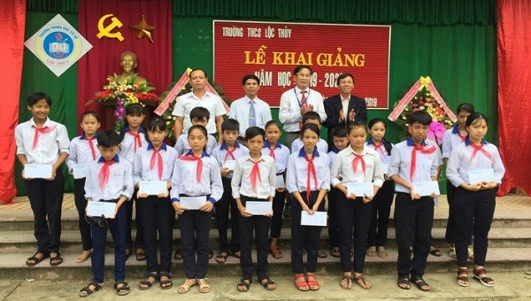 Nhà báo Nguyễn Quang Tám, Trưởng VPĐD Báo PLVN Khu vực Bình Trị Thiên cùng Lãnh đạo nhà trường trao quà cho các em.