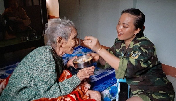 Nữ chiến sỹ chăm sóc bữa ăn cho người già có công, sức khỏe yếu tại trung tâm.