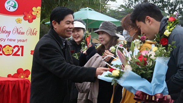 Ông Hoàng Hải Vân, Phó Giám đốc Vườn Quốc gia Phong Nha - Kẻ Bàng tặng hoa khách du lịch quốc tế đến xông đất ngày đầu năm.