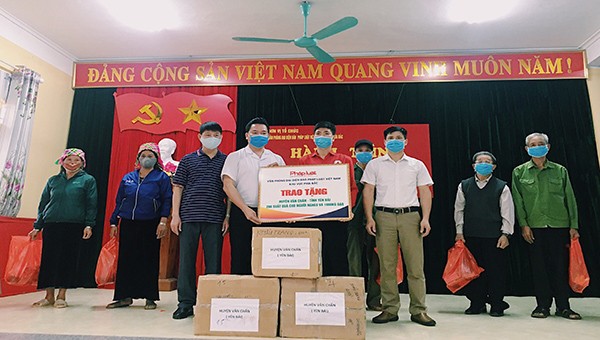 Nhà báo Vũ Đình Tiến và ông Nguyễn Thanh Hải trao quà cho huyện Văn Chấn