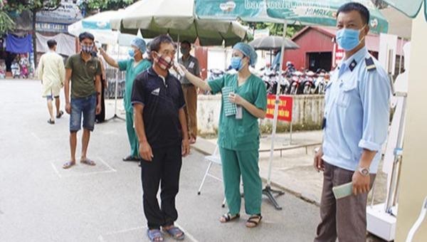 Kiểm tra thân nhiệt cho bệnh nhân và người nhà đến thăm khám tại Bệnh viện đa khoa tỉnh Sơn La.