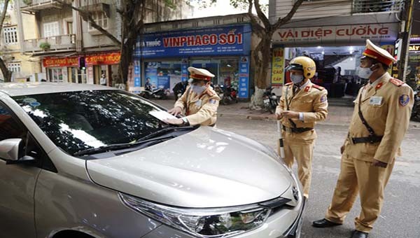 Lực lượng CSGT Công an tỉnh Vĩnh Phúc tiến hành xử phạt nguội và dán giấy thông báo xe ô tô dừng, đỗ sai quy định.