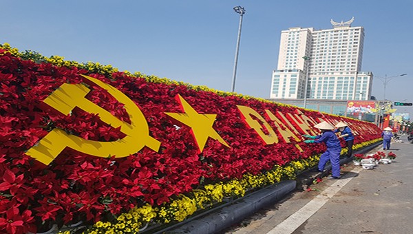 Các công nhân đang gấp rút hoàn thành công trình khẩu hiệu bằng hoa tại quảng trường Hùng Vương chào mừng Đại hội.
