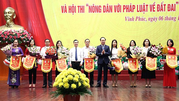 Chủ tịch Hội Nông dân tỉnh Nguyễn Thanh Tùng và Giám đốc Sở Tư pháp Nguyễn Văn Bắc tặng hoa và cờ lưu niệm cho các đội tham dự hội thi