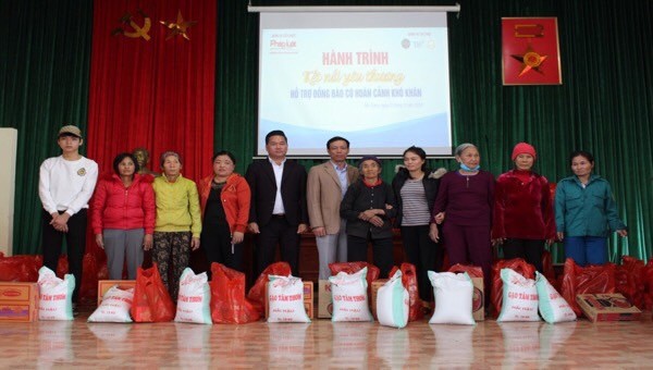Nhà báo Vũ Đình Tiến và ông Hoàng Văn Toán - Phó Chủ tịch thường trực UBND huyện trao quà cho người dân.