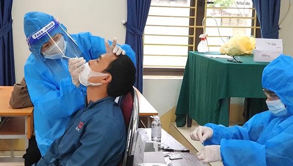 Giáo viên trường THCS Hưng Hóa, huyện Tam Nông lấy mẫu xét nghiệm COVID-19 cho người dân. (Ảnh: Hạnh Thúy)