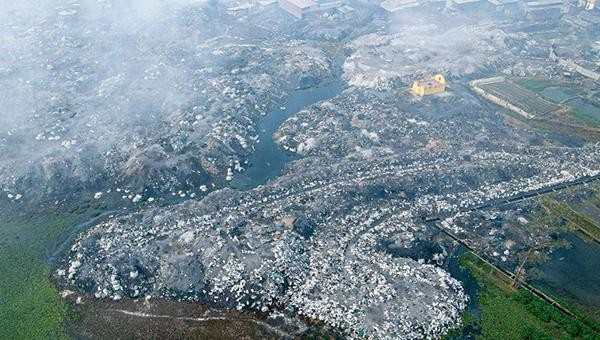 Bao trùm khắp ngôi làng Mẫn Xá là một làn khói xám mịt mù với hàng núi chất thải xỉ nhôm