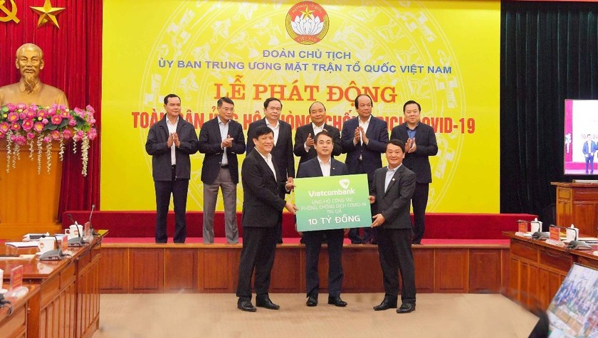 Đ/c Nghiêm Xuân Thành – Chủ tịch HĐQT Vietcombank (đứng giữa) - trao biển tượng trưng số tiền ủng hộ công tác phòng, chống dịch Covid-19 của Vietcombank.