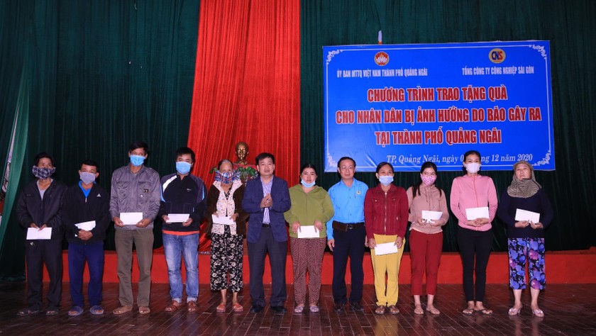 Bí thư Thành ủy Quảng Ngãi Nguyễn Cao Phúc (thứ 6, từ trái qua) và Chủ tịch Công đoàn CNS Trần Hữu Trung (áo xanh) tặng quà cho bà con ở TP Quảng Ngãi.